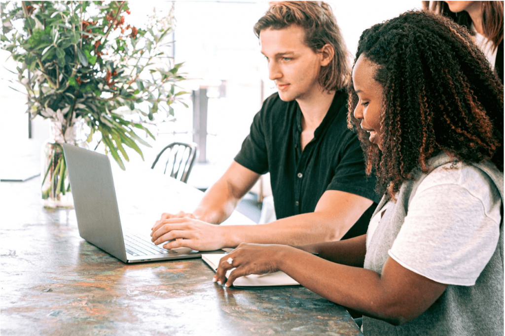 Millennial employees; a young man and woman work together on a laptop at a desk
