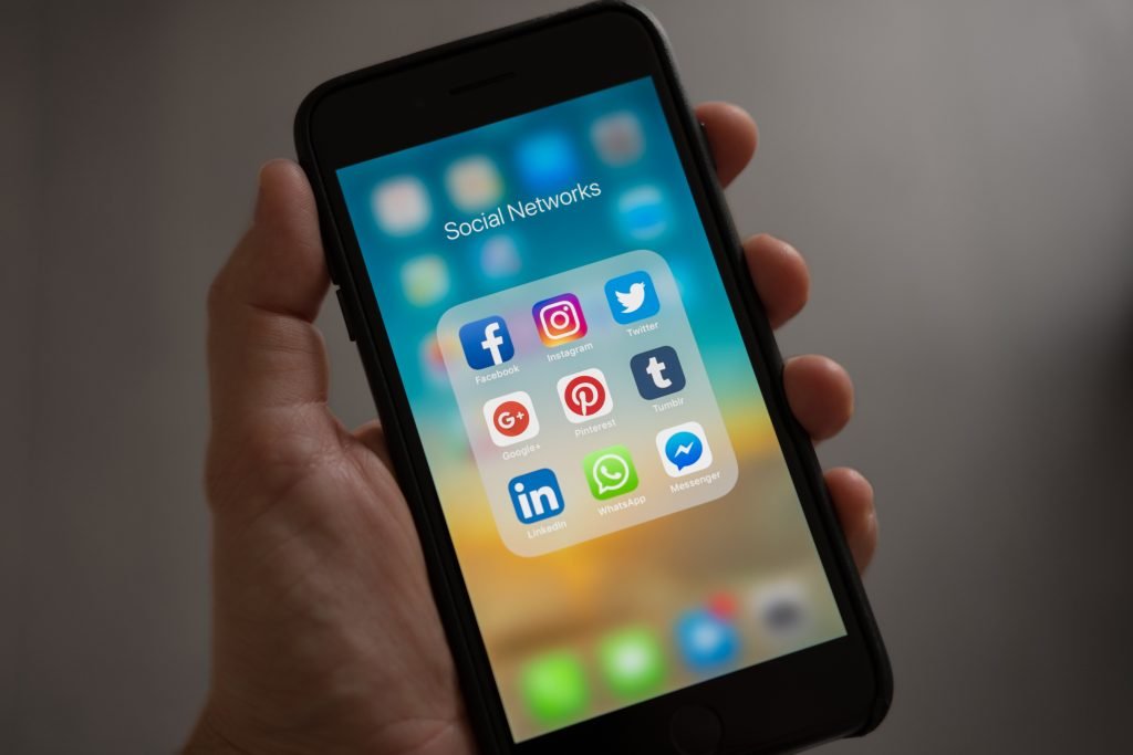 hand holding phone with social media applications