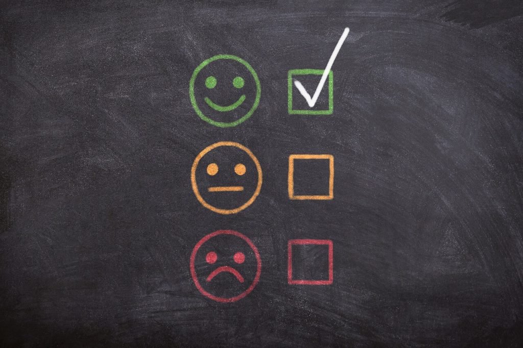 Rejecting candidates; happy, indifferent, and sad smiley faces, with a checkmark beside the happy one