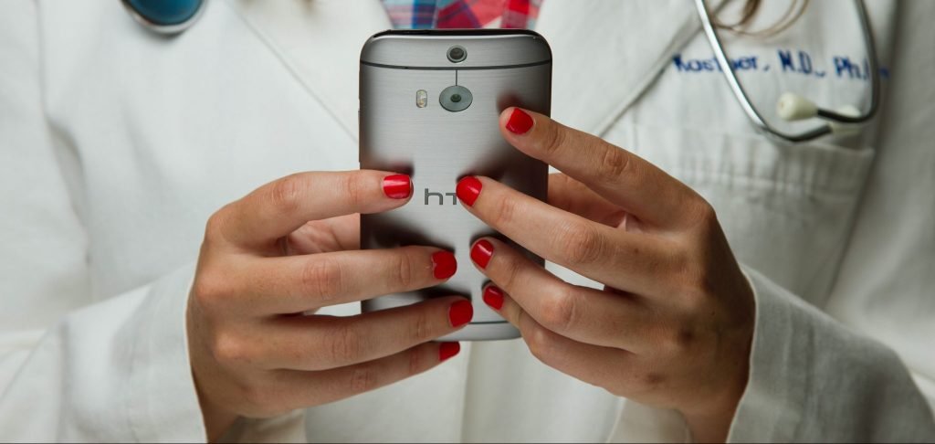 Doctor holding phone; Crafting HIPAA-Compliant Review Responses