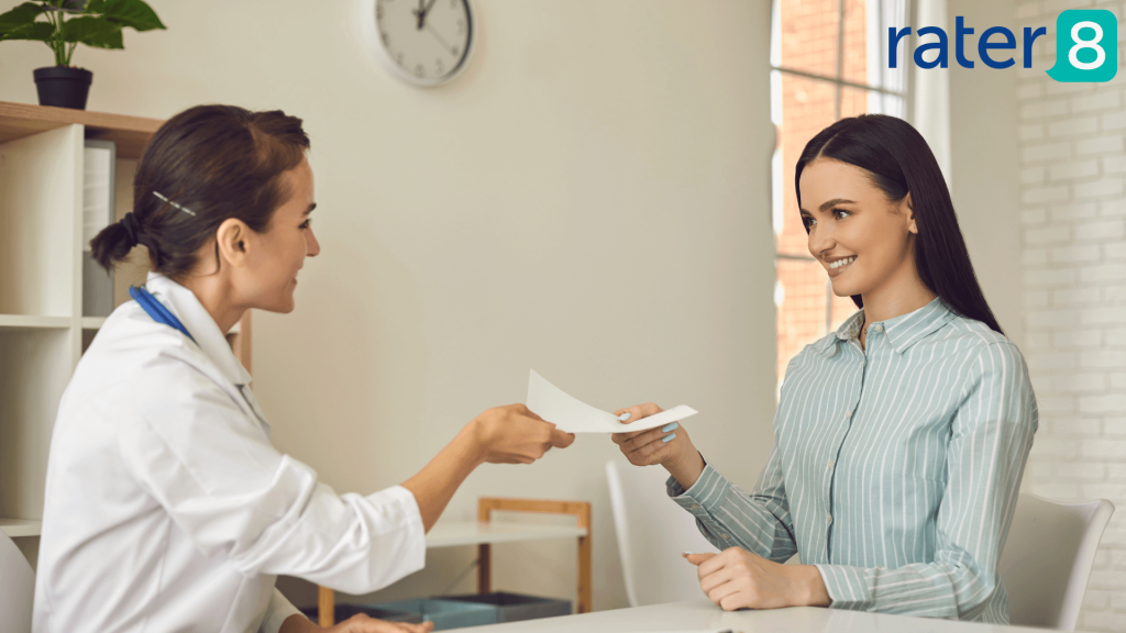 Featured image for rater8 blog on improving patient retention, showing a happy patient handing paperwork to their provider.