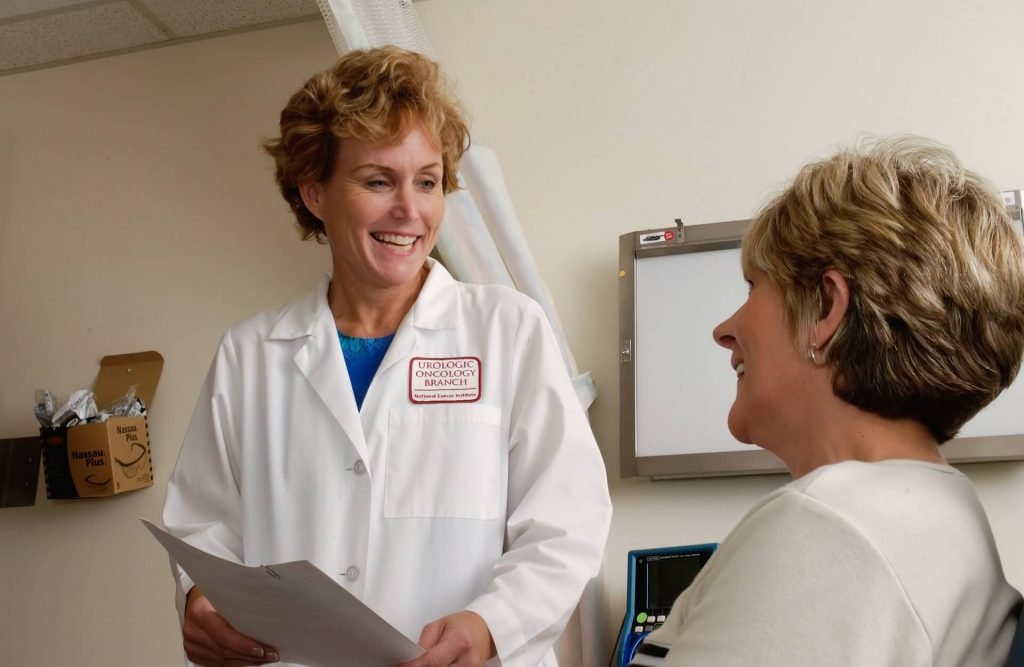 Female doctor smiles while talking with patient.