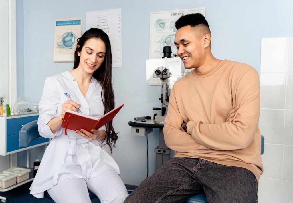Doctor and patient sitting in exam room, taking notes.