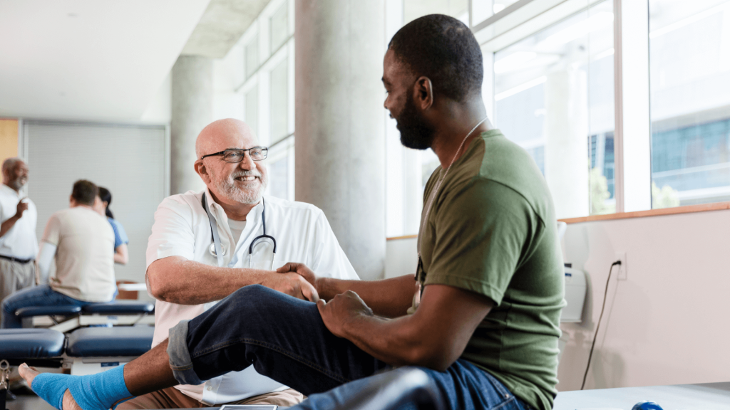 A smiling doctor works with a patient; Fostering a Culture of Excellence