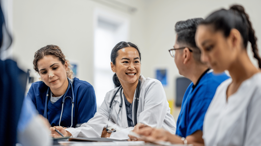Four healthcare workers sitting together during a team meeting