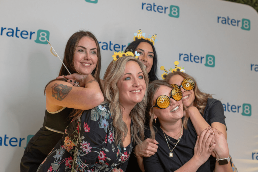 rater8 employees pose in front of photobooth at the IRL 2024 event